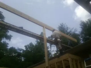 Carpenter setting a ridge beam over a new addition frame — Ice Dam Removal by Roofing Brothers in Aroda