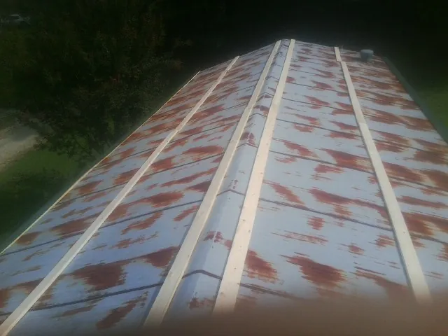 Rusted metal roof panels with new wood purlins before replacement — Storm Damage Roof Repair in Aroda by Roofing Brothers