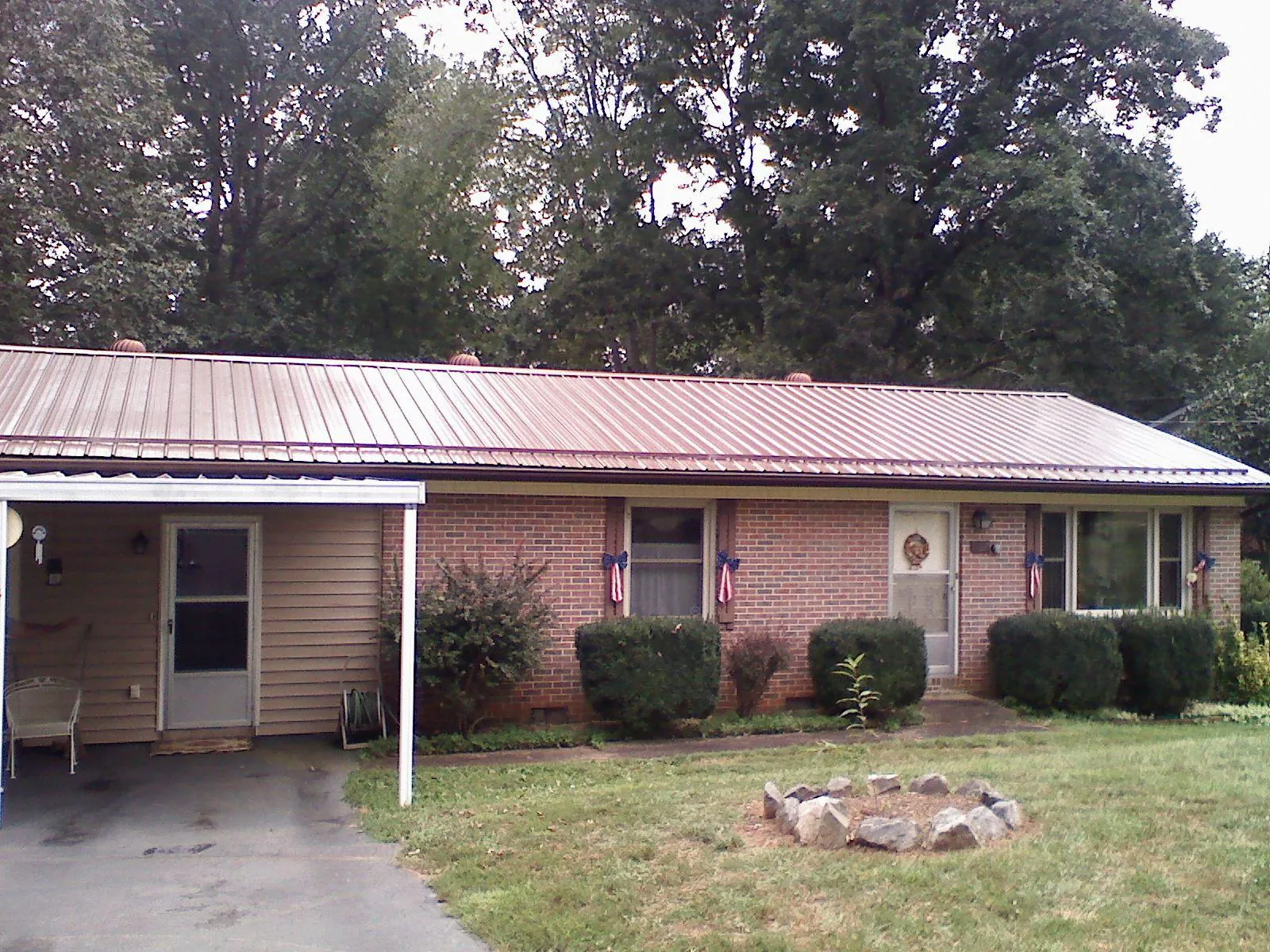 Bronze metal roof and carport on a brick ranch home — Roof Repair work by our crew in Aroda